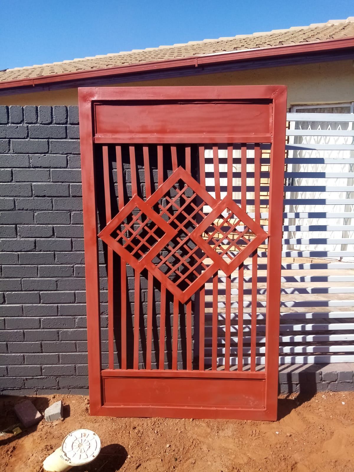 Powder-coated steel gate with a geometric feature panel
