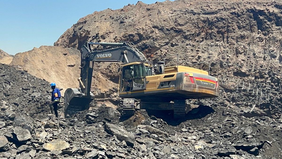 Excavator loading broken rock in a quarry